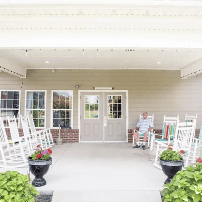 Resident enjoying the outdoor space with rocking chairs