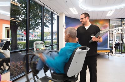 Therapist assisting a resident in a fitness room