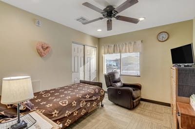 A cozy resident room with furniture and a window