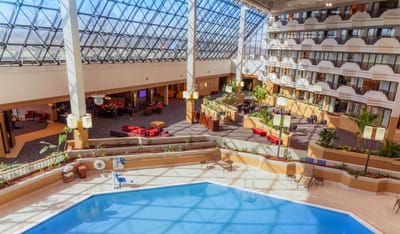 Indoor pool area surrounded by seating and plants