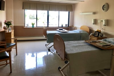 Private resident room with two beds and a window