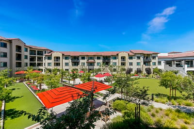 Outdoor space with red umbrellas and green gardens