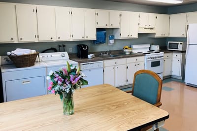 Bright and clean kitchen area with flowers on the table