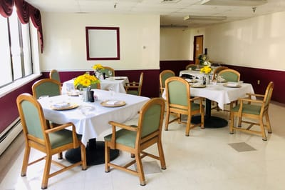 Dining room set for a meal with flowers on each table