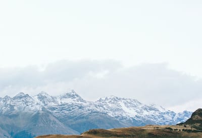 Snow-capped mountains under a cloudy sky