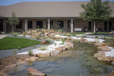 Outdoor courtyard with landscaping and a pond