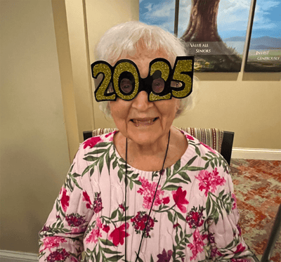 Resident wearing 2025 glasses at a celebration