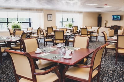 Dining area with tables and chairs set for meals.