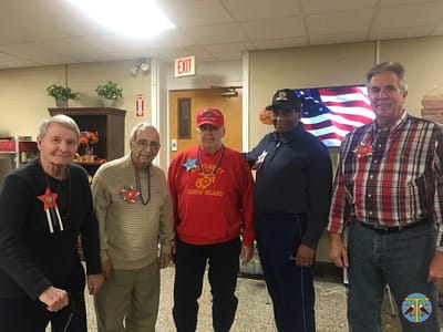 Residents and staff celebrate an event together indoors.