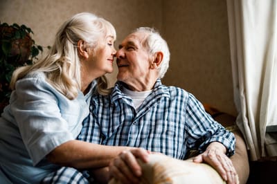 Elderly couple sharing a tender moment indoors