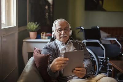 Senior man using a tablet in a cozy space.