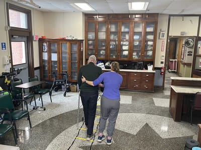 Staff assisting a resident in an interior space