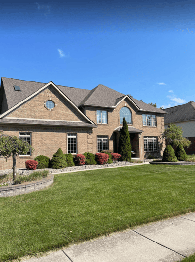 Residential exterior of a brick building with landscaping.