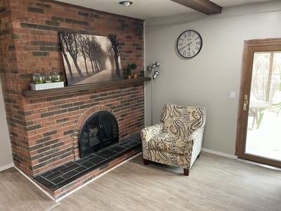 Cozy common area with a fireplace and armchair