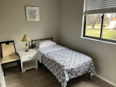 Simple single room with bed and chair.