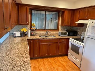 Bright kitchen area with wood cabinets and countertop.