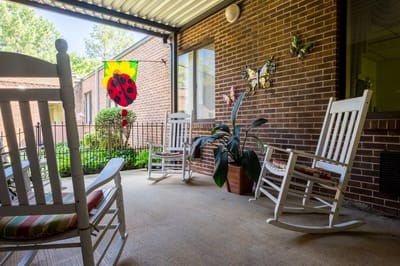 Outdoor seating area with rocking chairs and decorations.