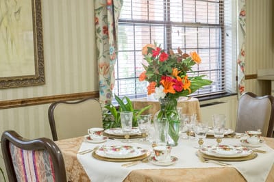 Elegantly set dining table with floral centerpiece.