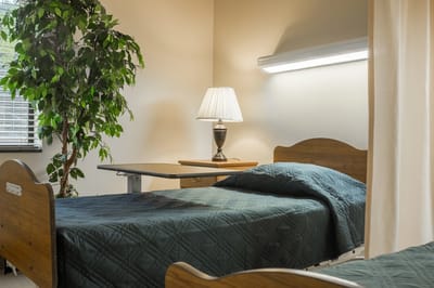 Cozy resident bedroom with a lamp and green bedding.