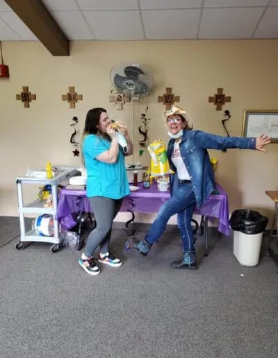 Two staff members celebrating with props.