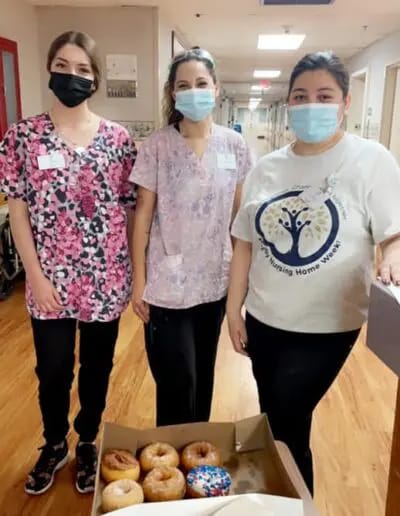 Staff members with donuts in a corridor