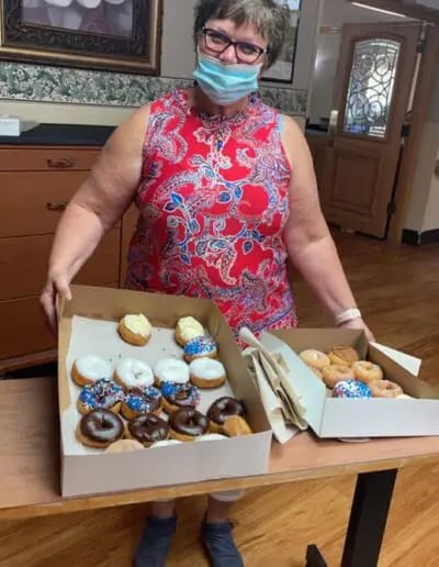 Staff member presenting a selection of donuts