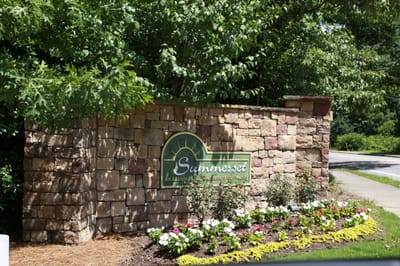 Facility entrance signage with flowers and greenery