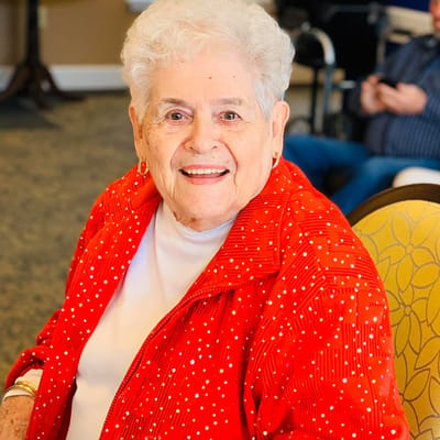 Resident smiling in a vibrant red jacket