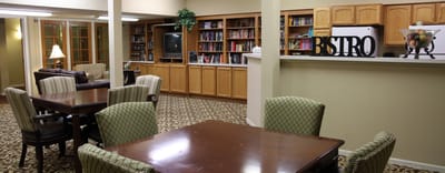 Common area with tables and bookshelves in a cozy setting