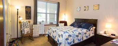 Cozy resident room with a bed and rocking chair