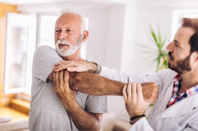 Therapist assisting a senior in a facility setting