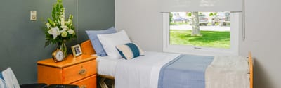 Bright private resident room with bed and decorations