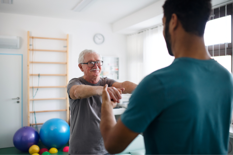 Physical therapy session with older man and staff member