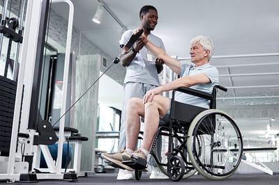 A staff member assisting a resident in a gym