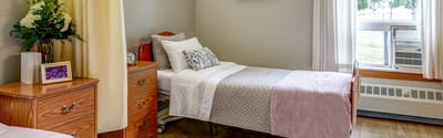 A private resident room with bed and furniture