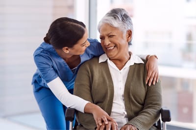 Caregiver and resident sharing a joyful moment indoors