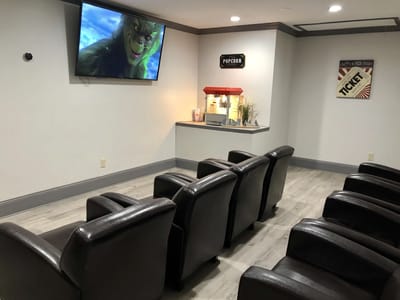 Seating area with a movie screen and popcorn machine.