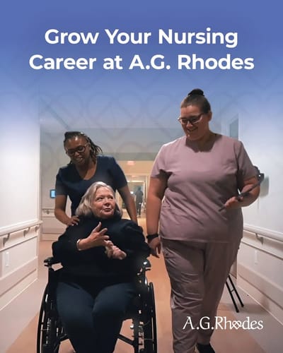 Staff assisting a resident in a hallway.