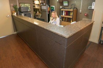 Reception area with staff member at the desk.