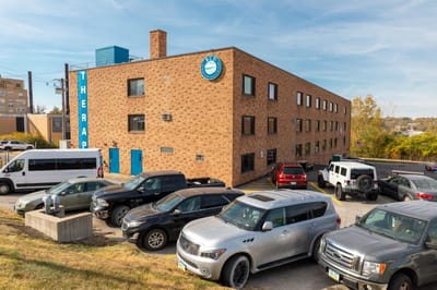 Exterior view of the rehabilitation center with vehicles