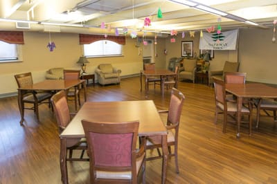 Common area with tables and chairs, decorated ceiling.