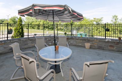 Outdoor seating area with umbrella and chairs.