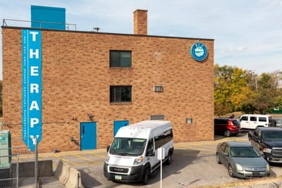 Exterior view of the therapy building with a transport van