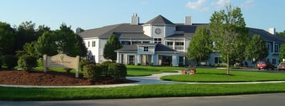 Exterior view of assisted living facility with landscaping.