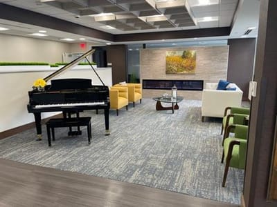 Interior lounge area with seating and a piano.