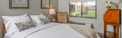 Cozy bedroom with window view and decorations.