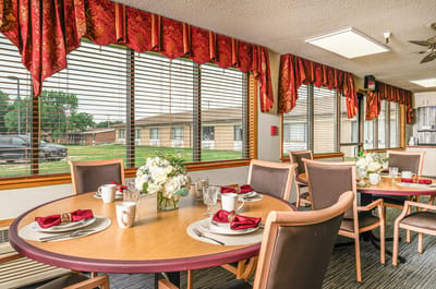 Dining area with set tables and flowers.