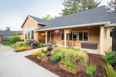 Front entrance of a residential facility with landscaped gardens.