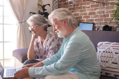 Two seniors enjoying time together on a couch.