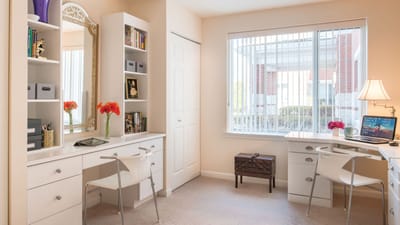 Brightly lit shared resident room with desks and decor